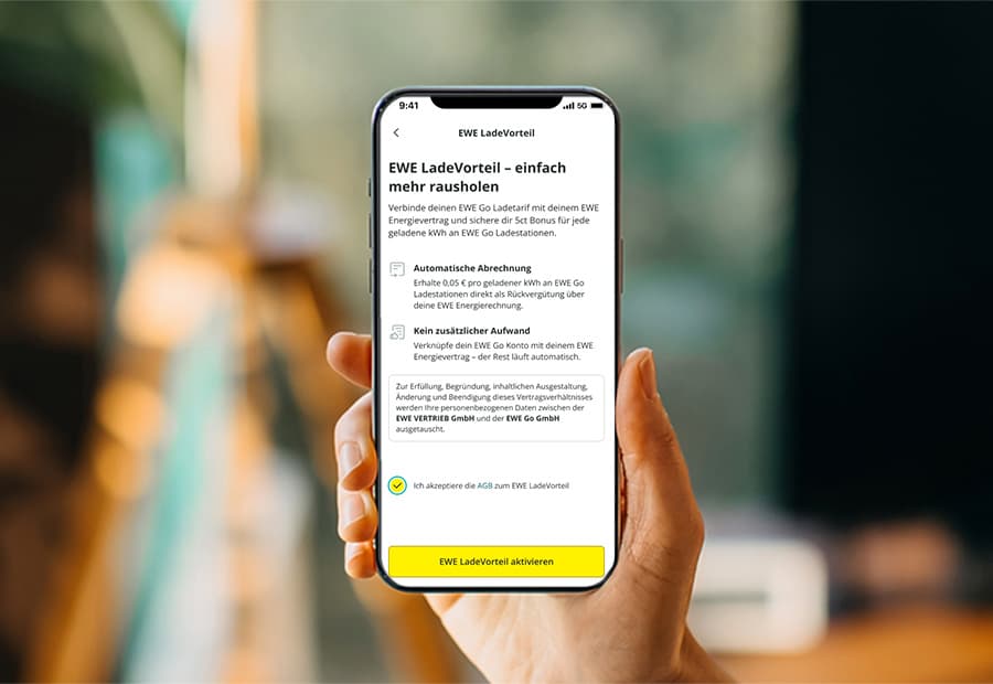 Hand hält ein Handy auf dem die Vorteile des EWE LadeVorteil zu sehen ist