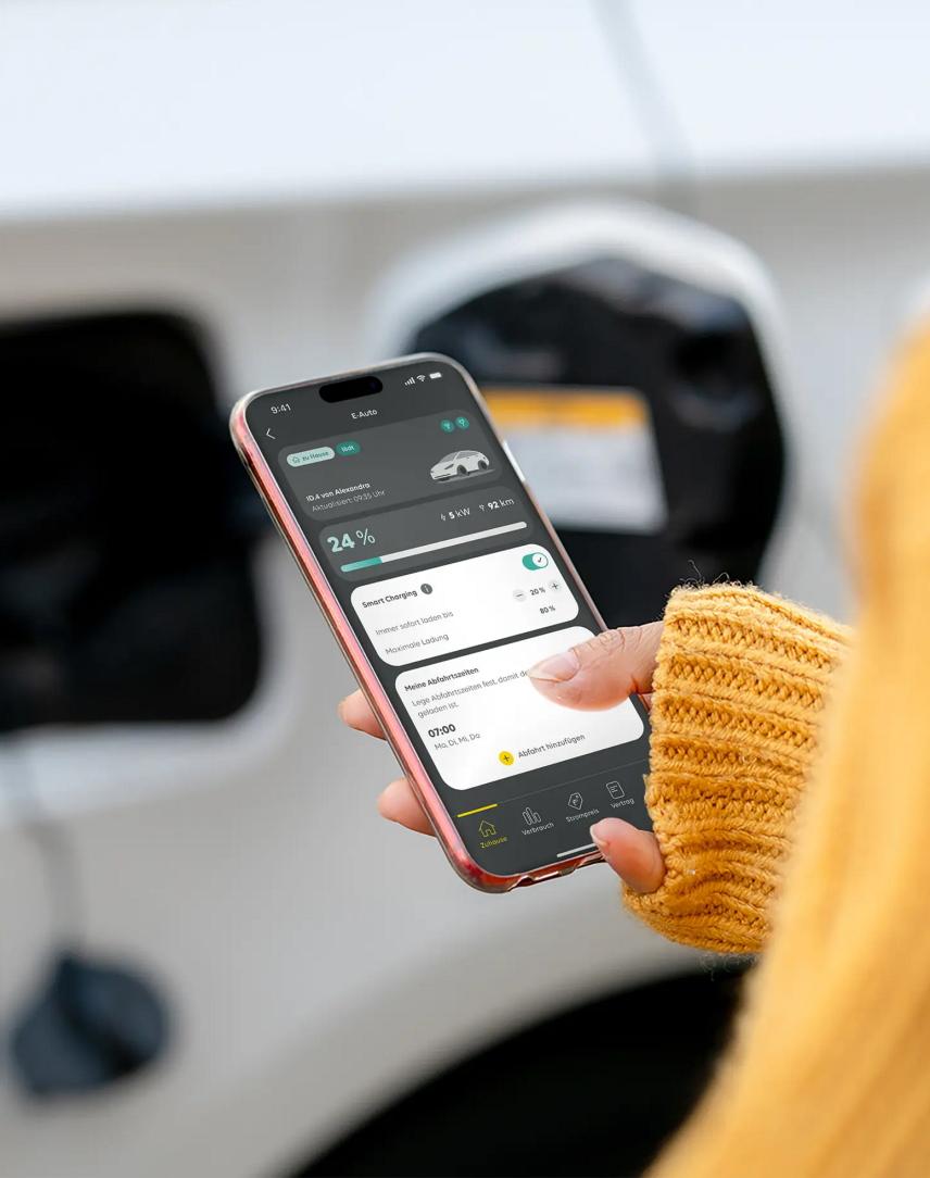 Eine Frau schaut auf die Mein EWE Energie App, während sie ihr Elektroauto lädt