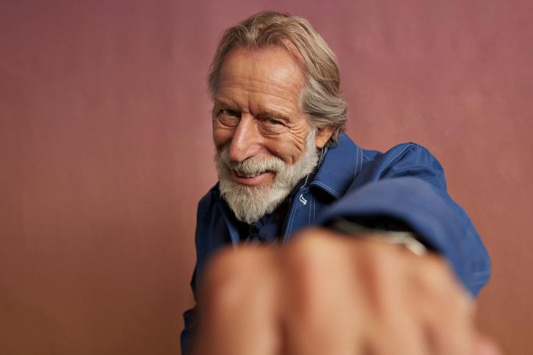 Älterer Herr mit Bart streckt Faust in Richtung der Kamera.