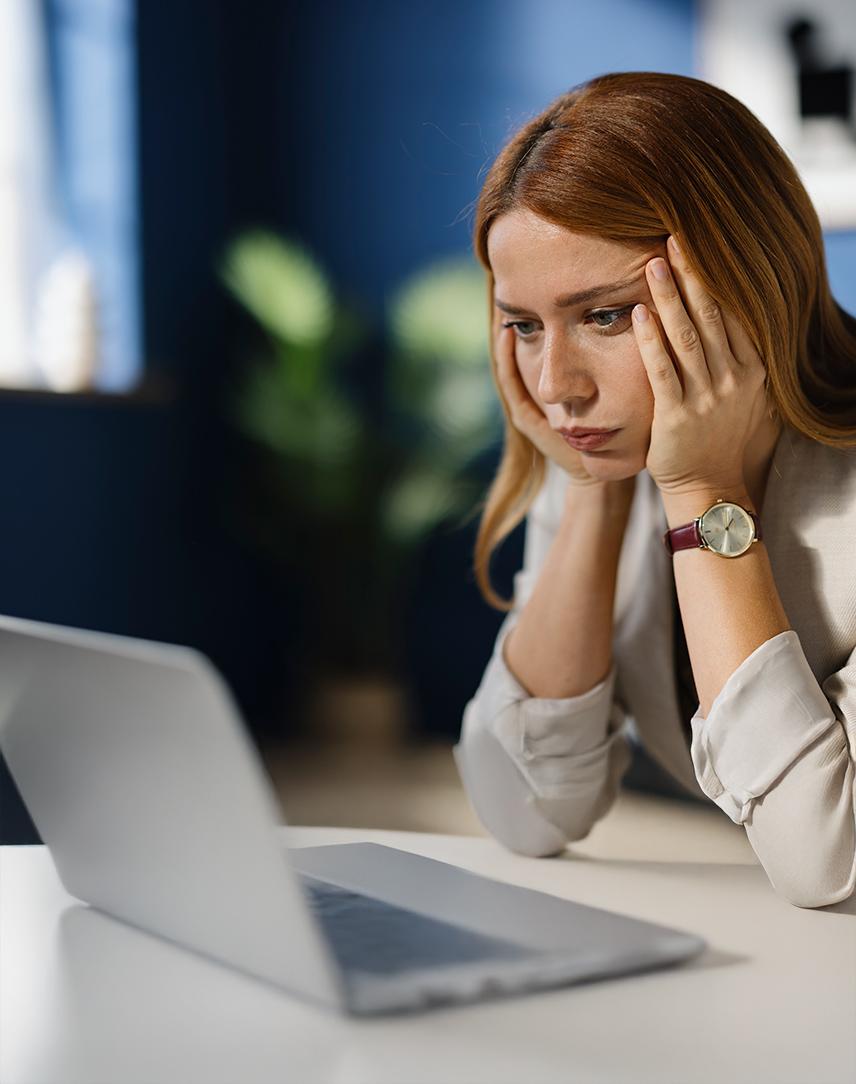 Frau schaut verzweifelt auf ihren Laptopbildschirm