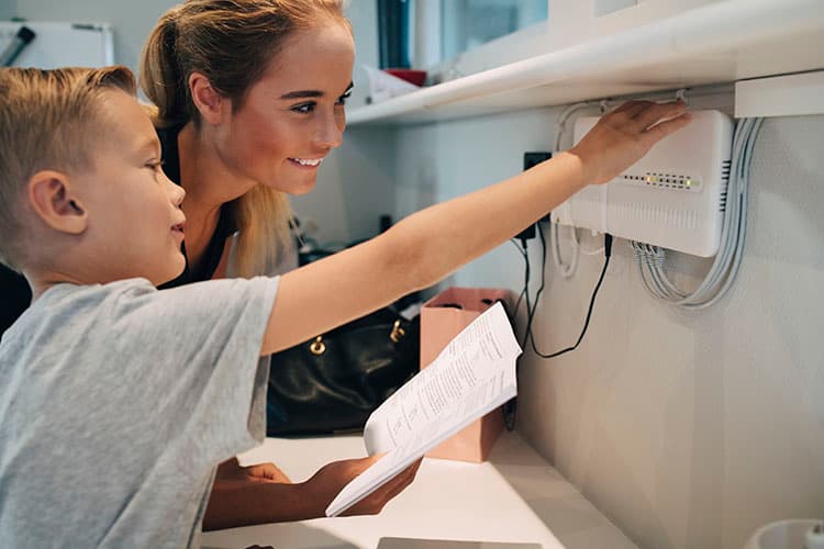 Mutter und Sohn schauen auf einen Router