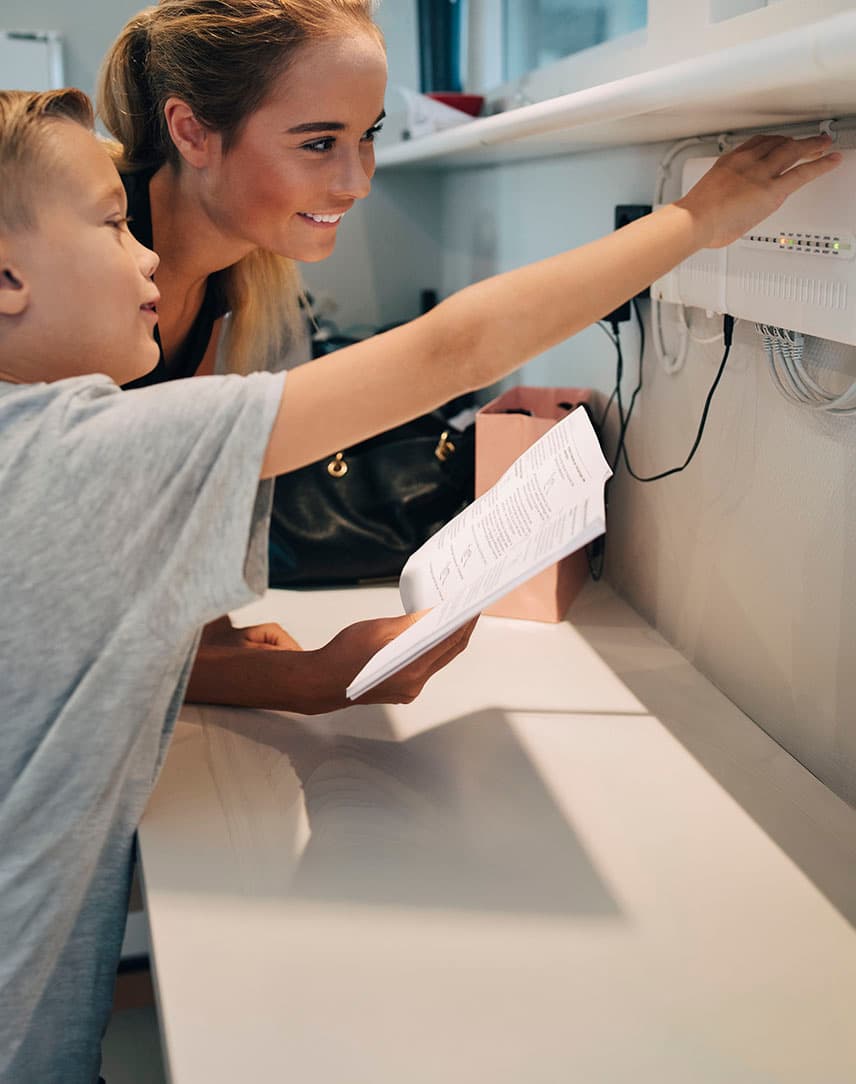 Mutter und Sohn schauen auf einen Router