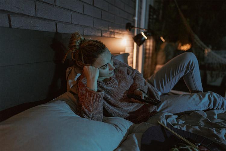 Frau liegt entspannt auf dem Sofa