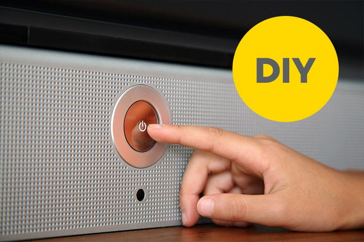 Finger, der Abschalt-Knopf am Fernseher drückt