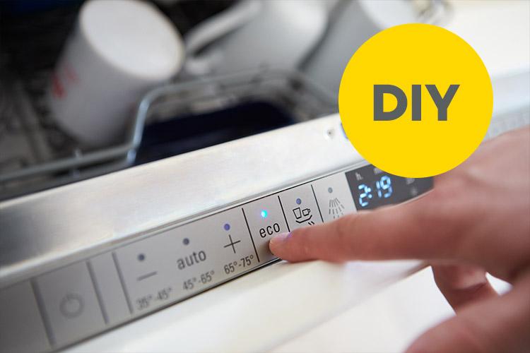 Finger der auf Eco-Modus an der Spülmaschine drückt