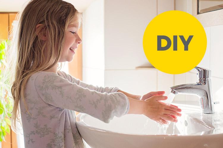 Mädchen wäscht sich im Badezimmer die Hände unter dem Wasserhahn.