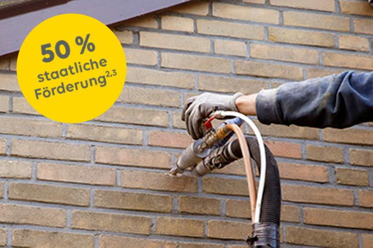Handwerker dämmt die Außenwand eines Hauses. Ein gelber Störer weist auf 50 % staatliche Förderung hin