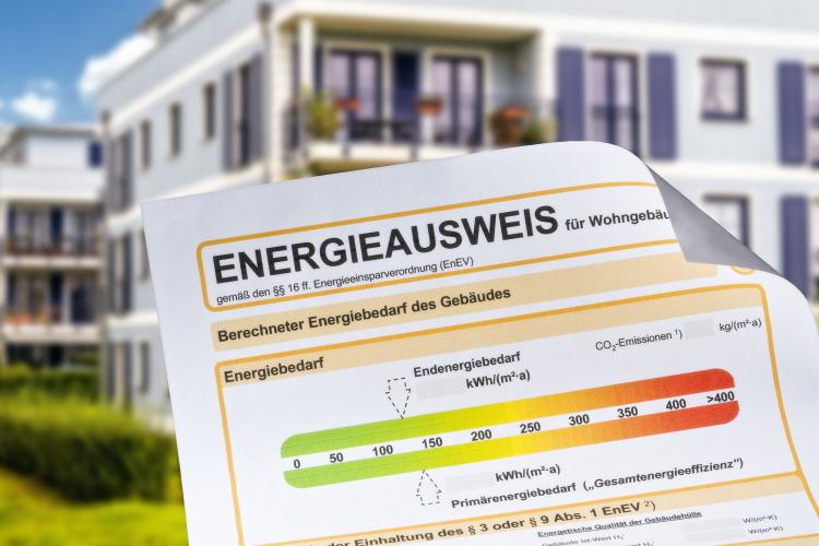 Symbolische Abbildung eines Energieausweises vor einer Gebäudereihe