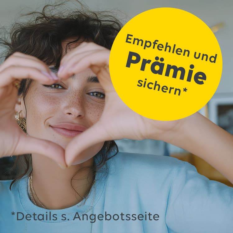 Eine Frau formt ein Herz mit ihren Fingern, durch das sie hindurchschaut.