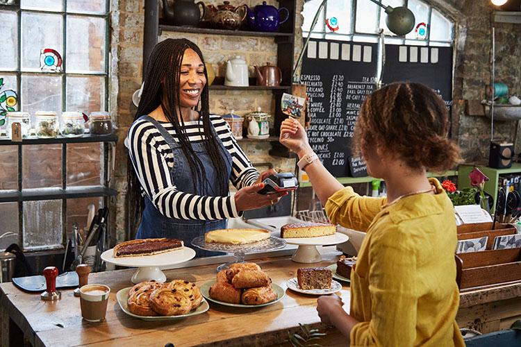Frau bezahlt in einem Geschäft mit Smartwatch