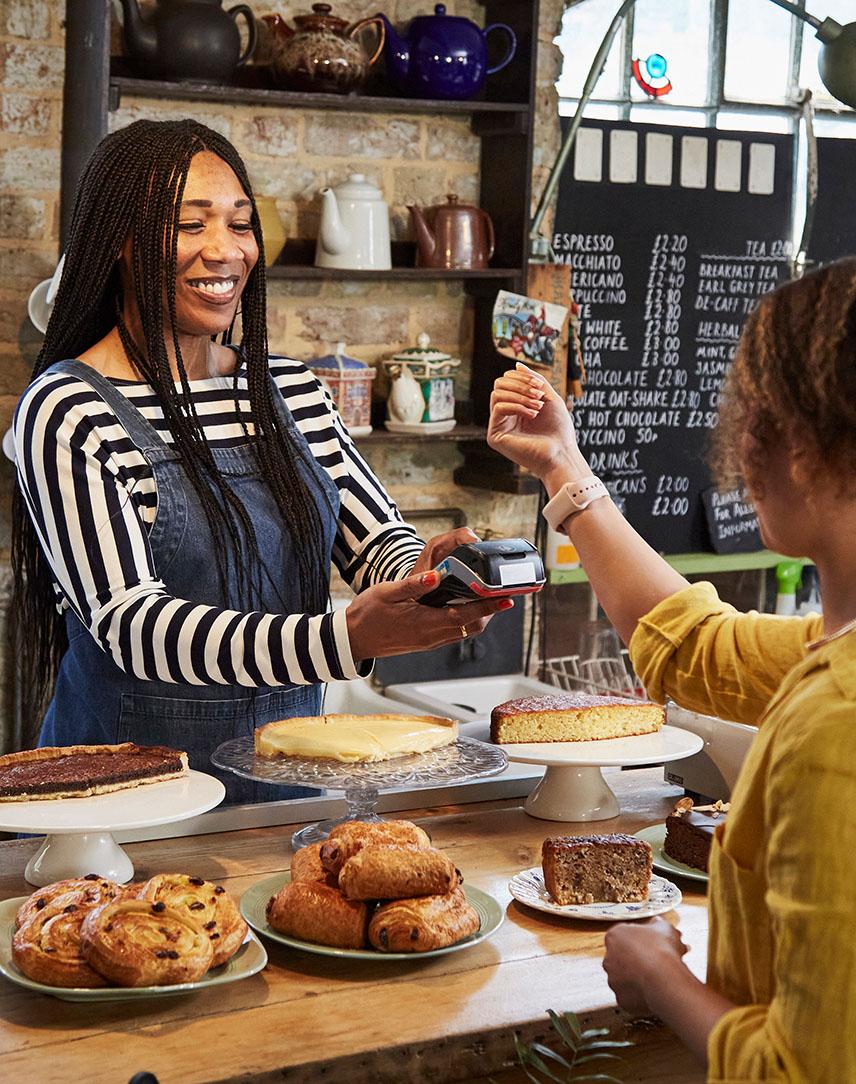 Frau bezahlt in einem Geschäft mit Smartwatch