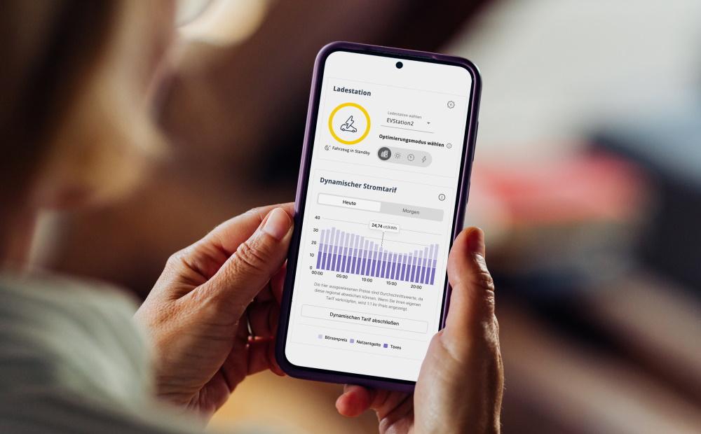 Eine Frau schaut sich auf dem Smartphone den EWE Energiemanager an