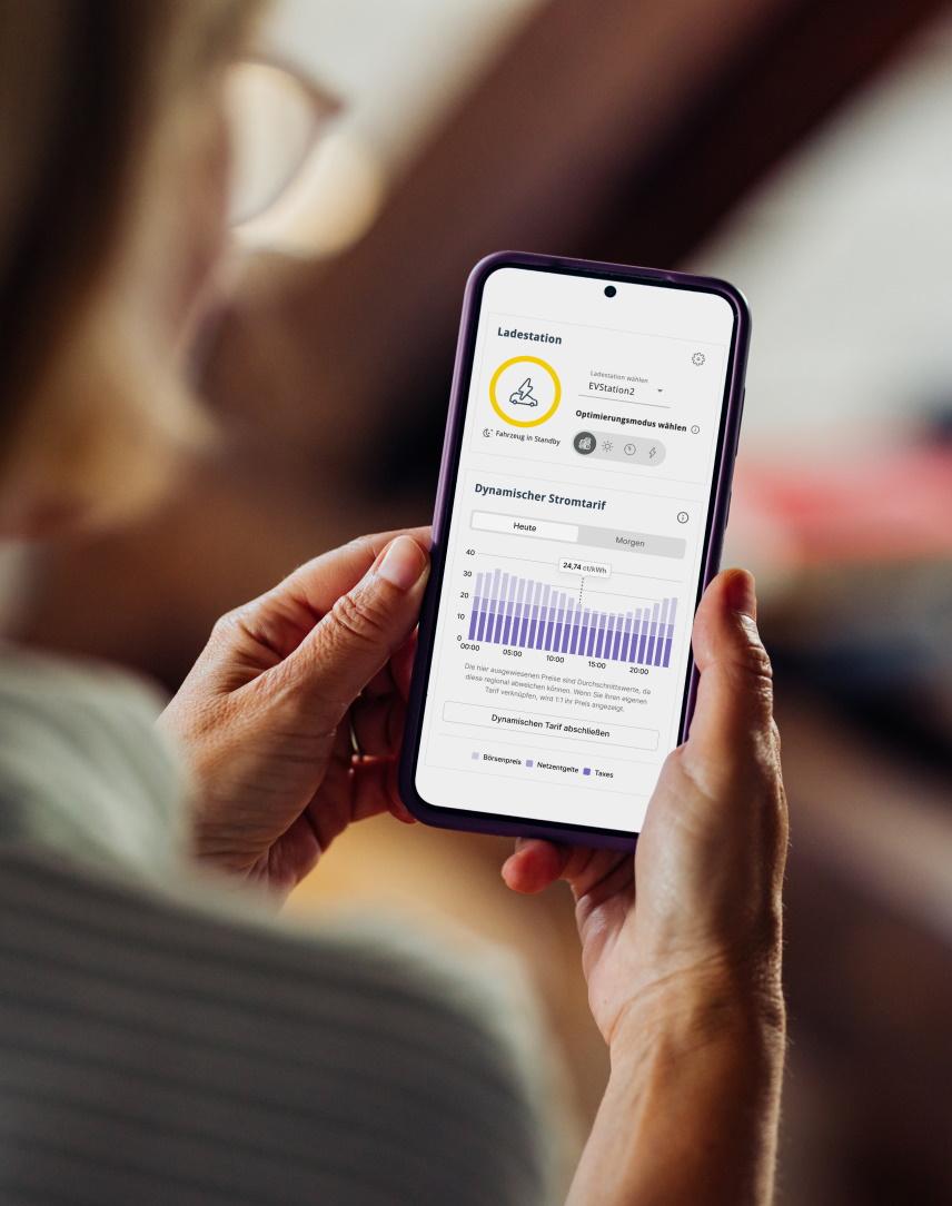 Eine Frau schaut sich auf dem Smartphone den EWE Energiemanager an