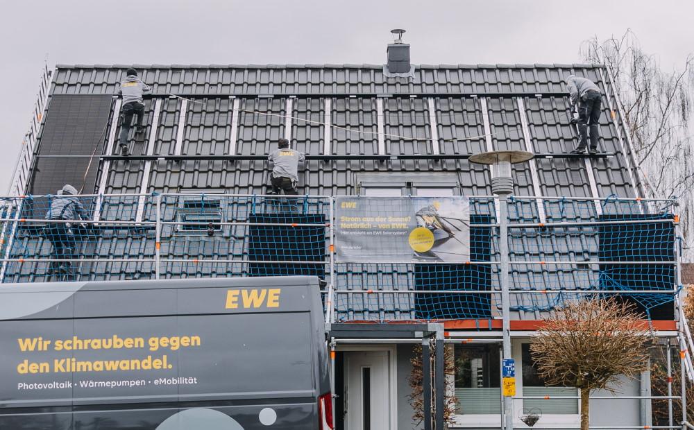 Fachhandwerker installiert Solarmodule auf einem Hausdach