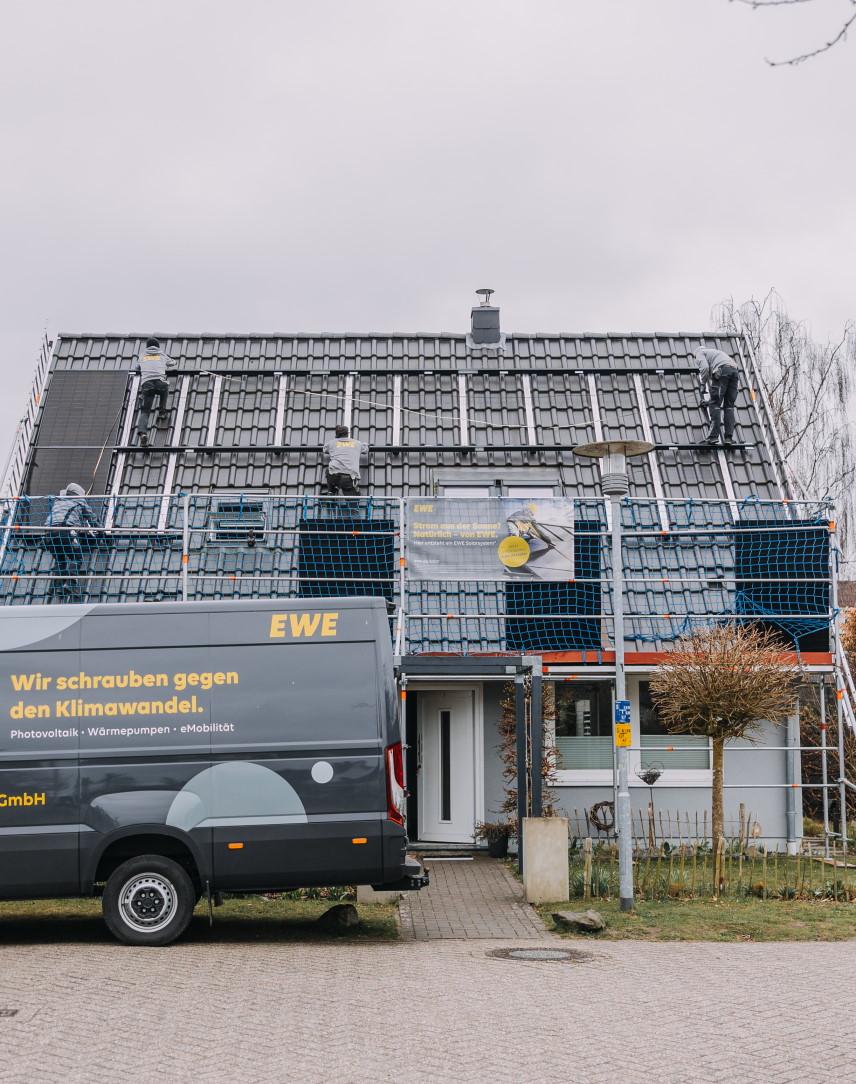Fachhandwerker installiert Solarmodule auf einem Hausdach