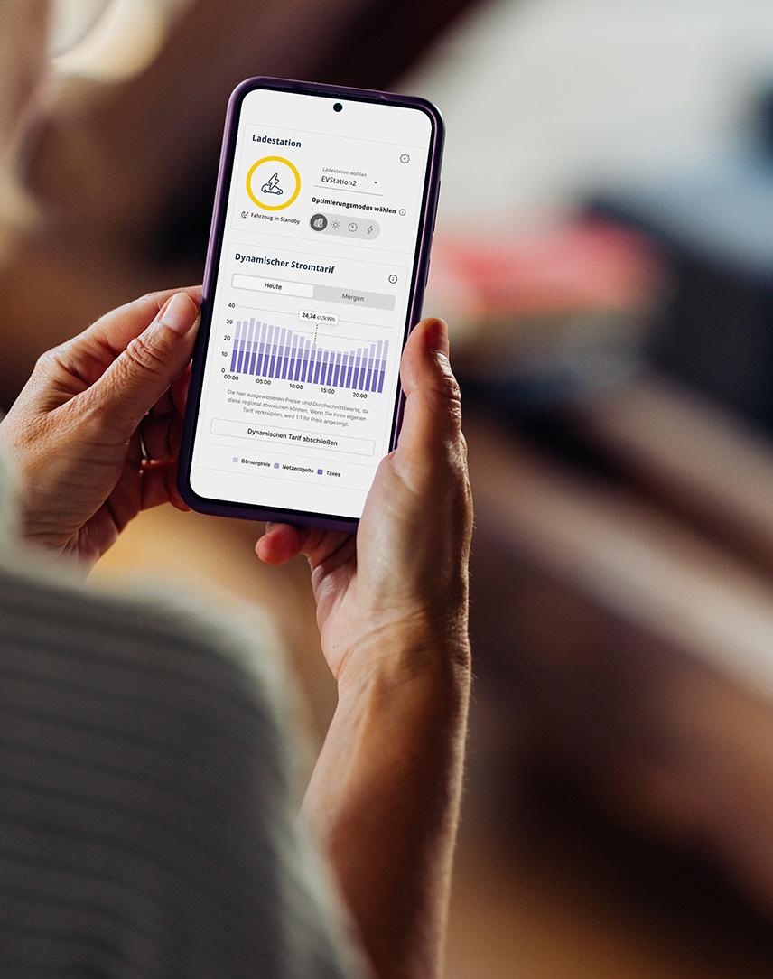 Frau mit Smartphone auf dessen Bildschirm der EWE Energiemanager abgebildet ist