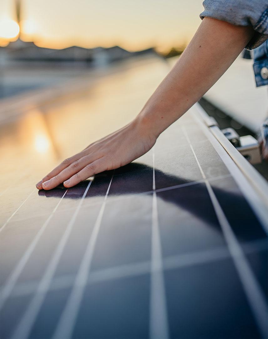 Hand streicht über PV-Modul