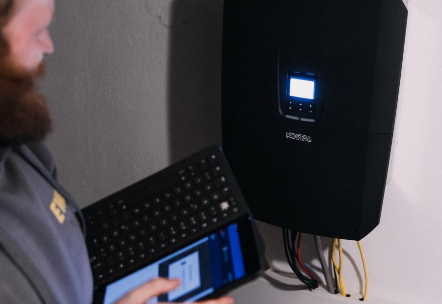 EWE-Mitarbeiter installiert Wechselrichter der Anlage von EWE-Solarkundin Kerstin