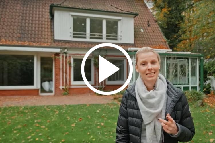 EWE-Smartgeberin Tomke vor einem Haus