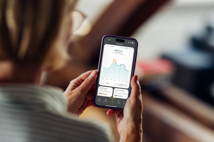Frau schaut auf ihrem Smartphone Informationen zu einem dynamischen Stromtarif an