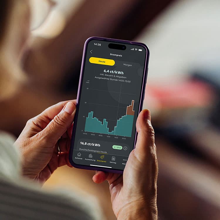 Frau schaut auf ihrem Smartphone Informationen zu einem dynamischen Stromtarif an
