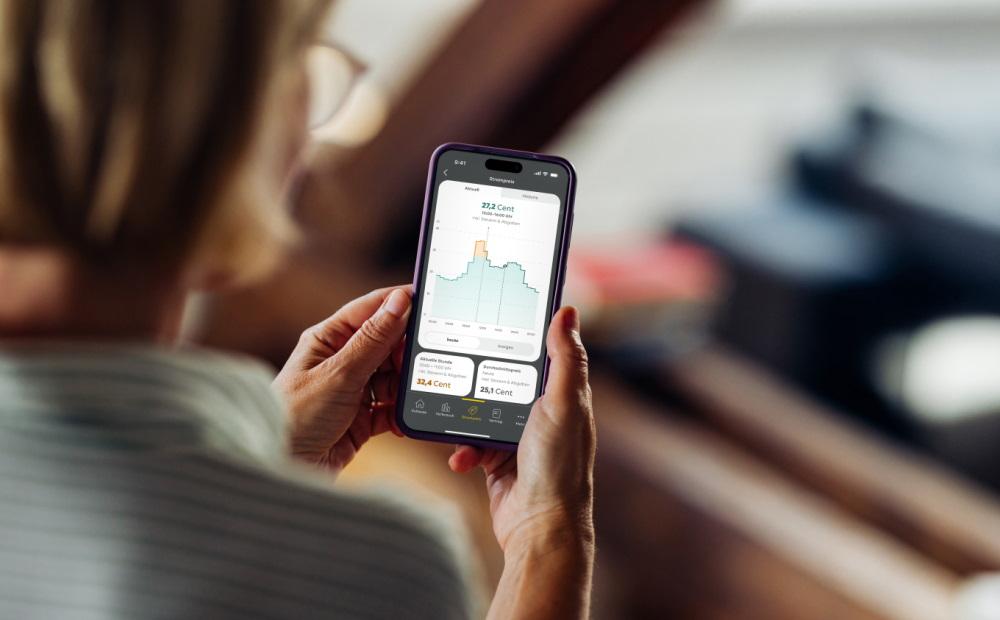 Frau schaut auf ihrem Smartphone Informationen zu einem dynamischen Stromtarif an