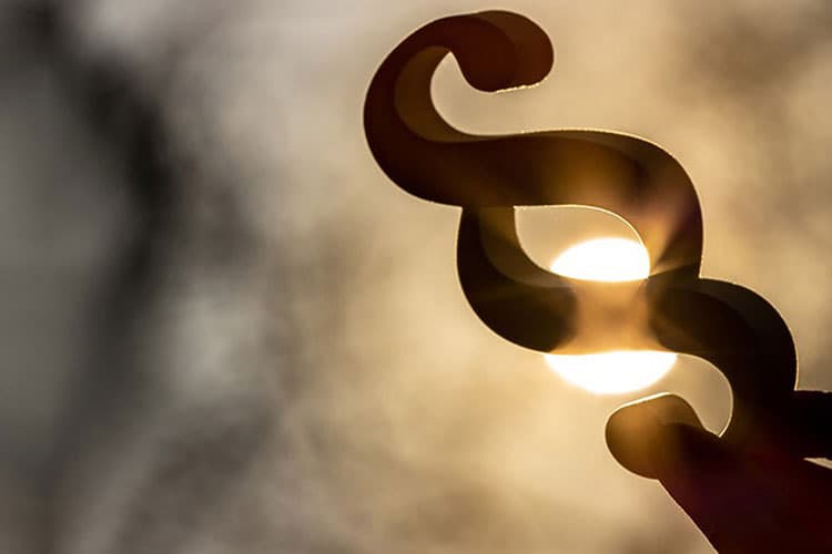 Ein Paragrafen-Symbol vor einer Sonne