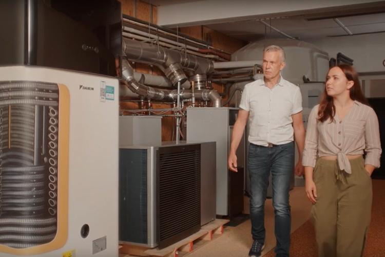 Ein Fachhandwerker und eine EWE-Mitarbeiterin schauen sich verschiedene Heizgeräte an