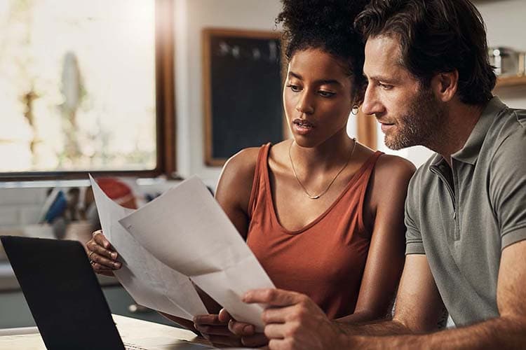  Mann und Frau schauen überrascht auf Unterlagen