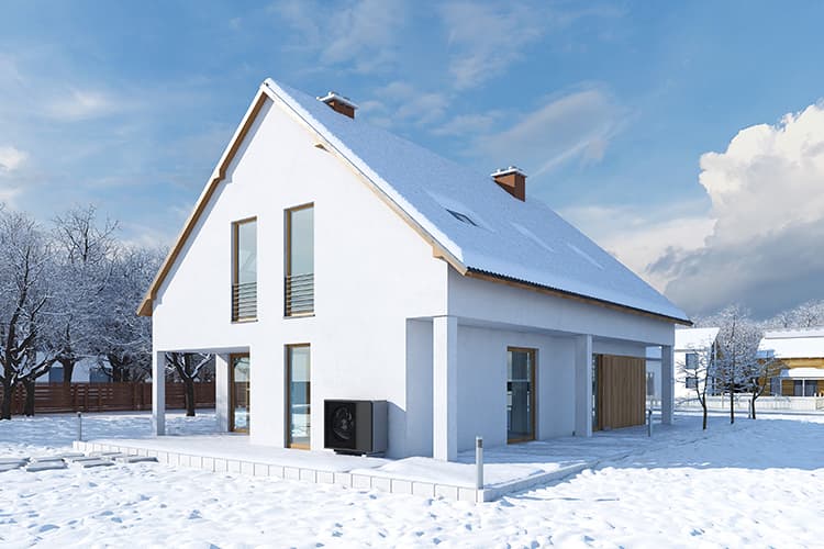 Haus mit Wärmepumpe in Schneelandschaft