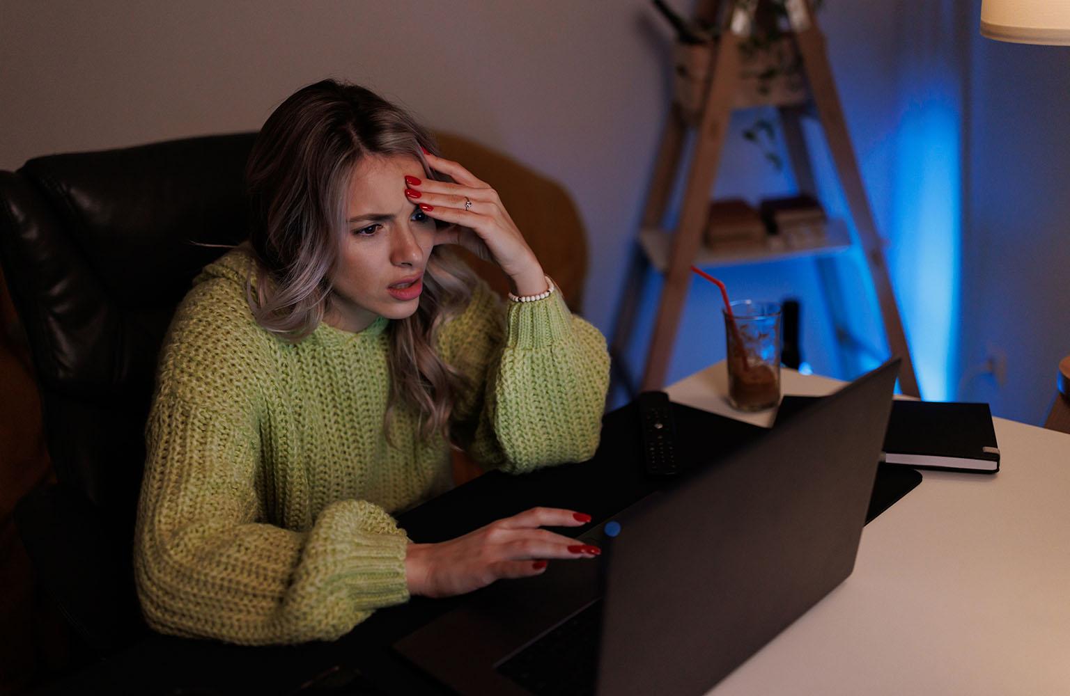 Frau sitzt verzweifelt am Laptop