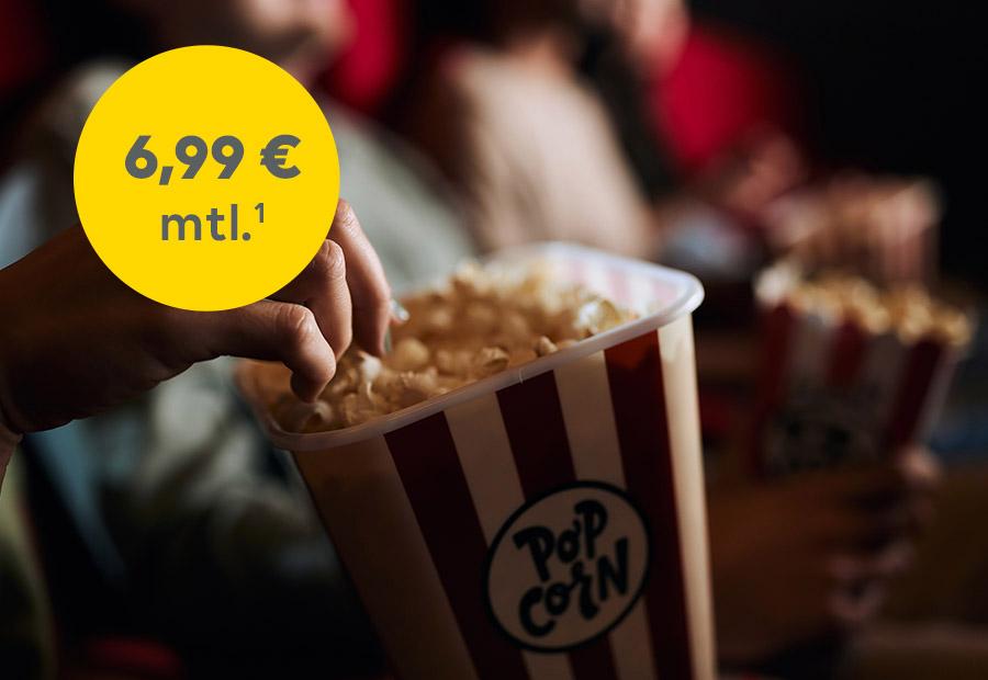 Hand, die in Popcornschachtel greift