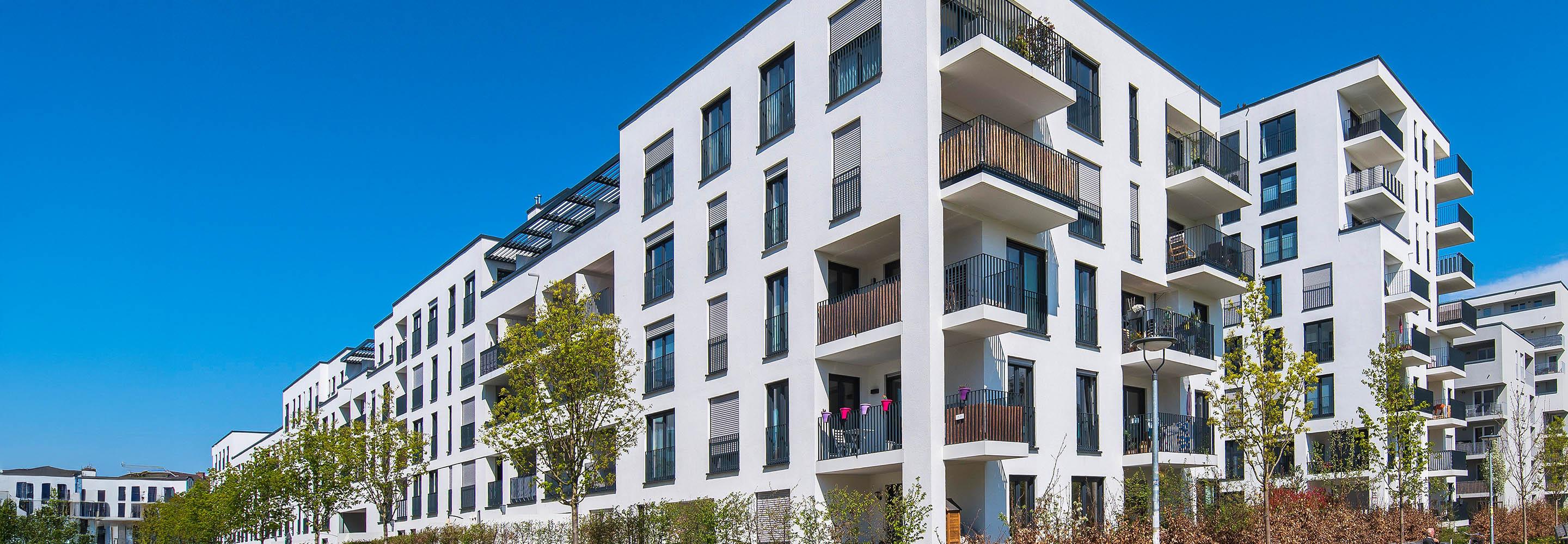 Weißes Mehrfamilienhaus mit Balkonen