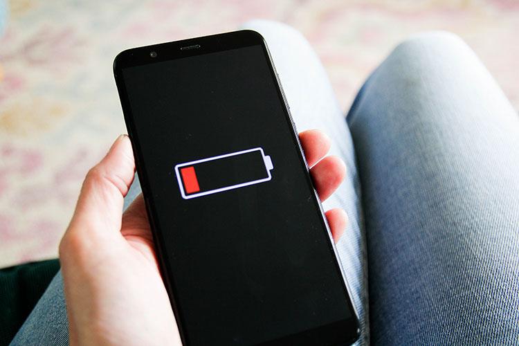 Smartphone mit roter Akkuanzeige auf dem Display