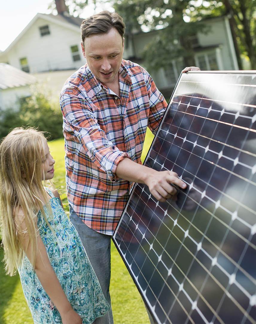 Vater zeigt seiner Tochter ein Solarmodul