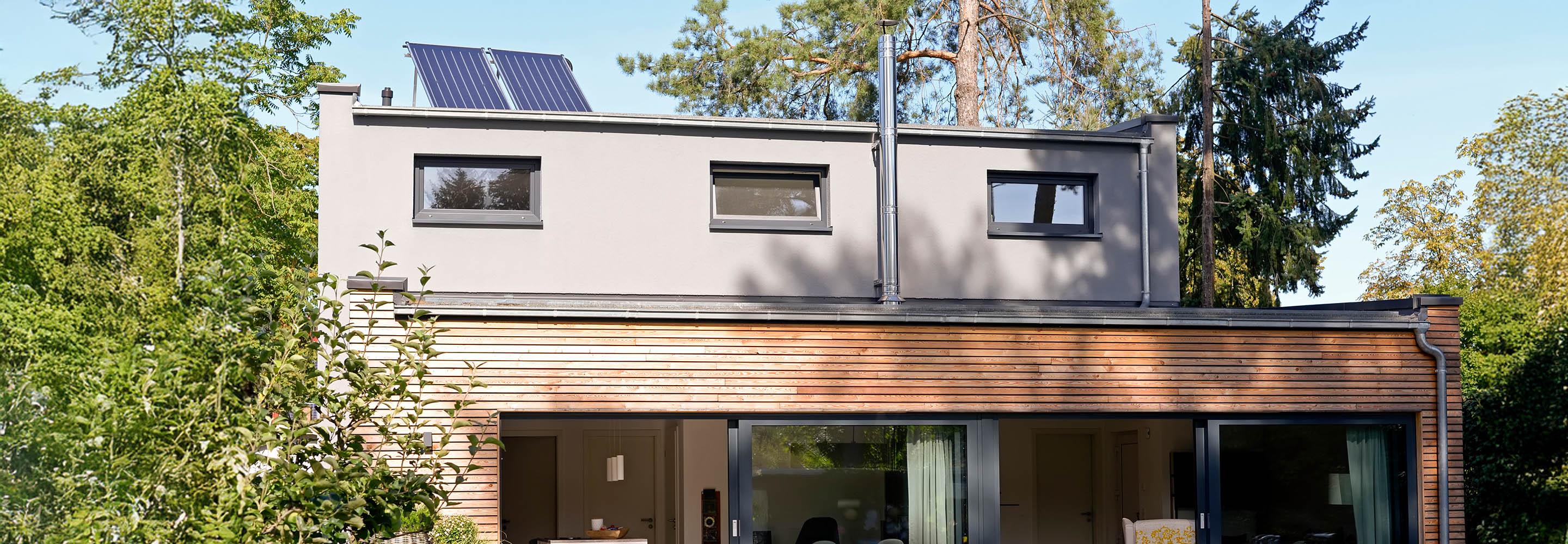 Haus mit einem Flachdach auf dem ein Solarmodul steht