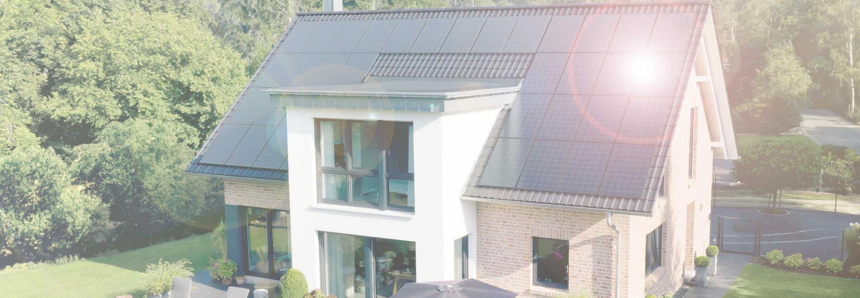 Haus mit Solarmodulen auf dem Dach, in denen Sonne reflektiert