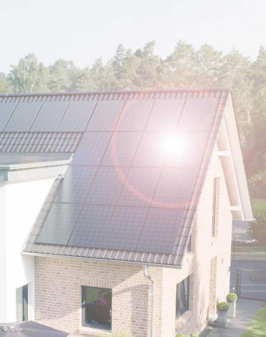 Haus mit Solarmodulen auf dem Dach, in denen Sonne reflektiert