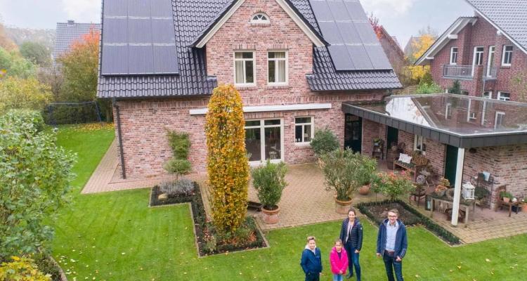 Familie Meistermann aus Vechta vor ihrem Haus mit Solarmodulen auf dem Dach