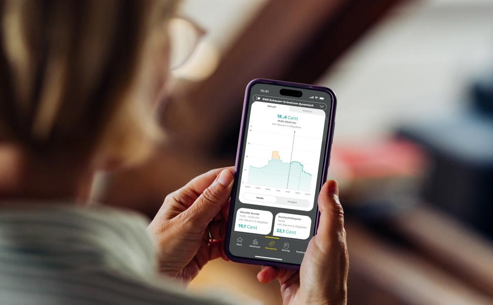 Frau schaut auf ihrem Smartphone Informationen zu einem dynamischen Stromtarif an