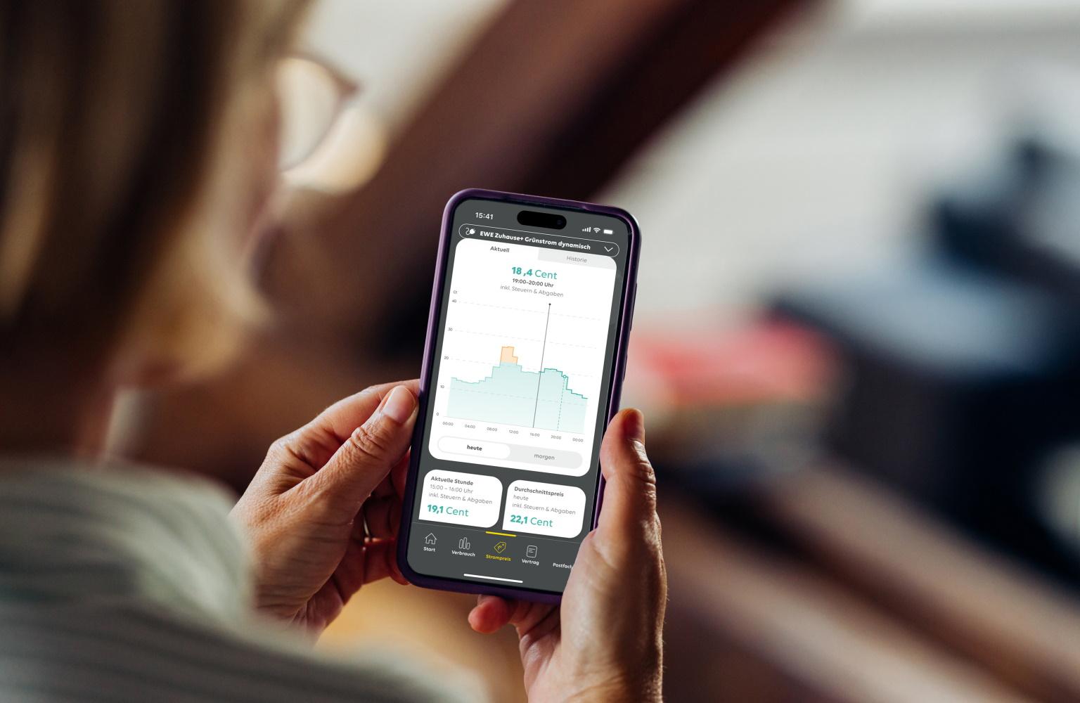 Frau schaut auf ihrem Smartphone Informationen zu einem dynamischen Stromtarif an