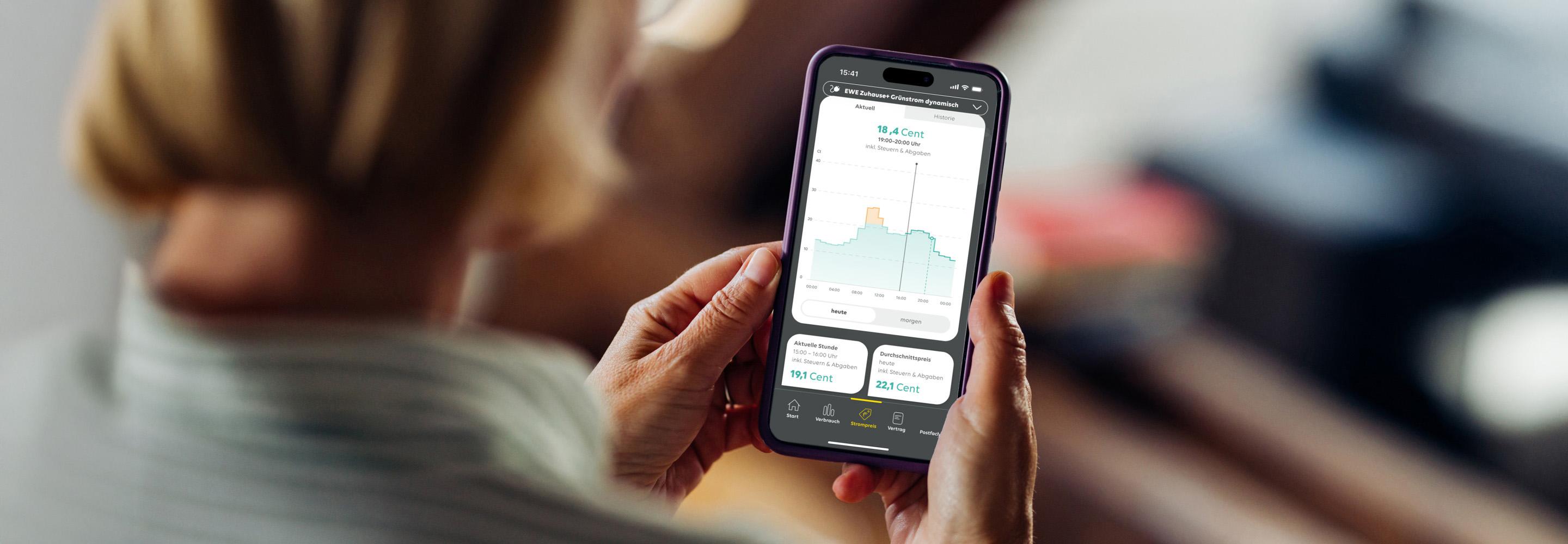 Frau schaut auf ihrem Smartphone Informationen zu einem dynamischen Stromtarif an