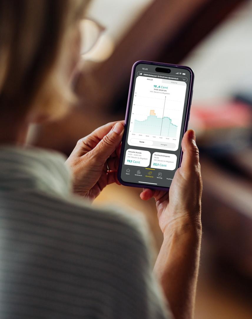 Frau schaut auf ihrem Smartphone Informationen zu einem dynamischen Stromtarif an