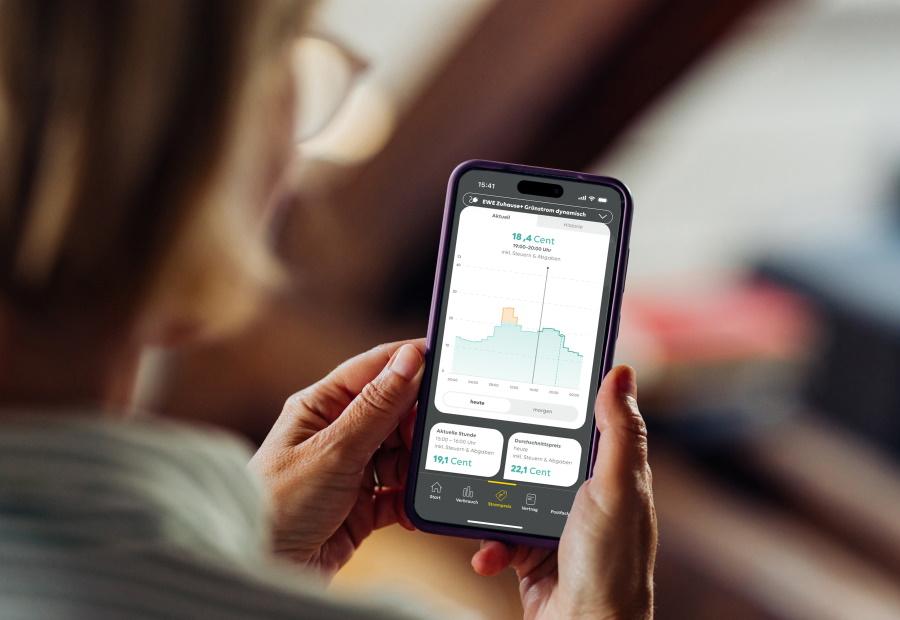 Frau schaut auf ihrem Smartphone Informationen zu einem dynamischen Stromtarif an