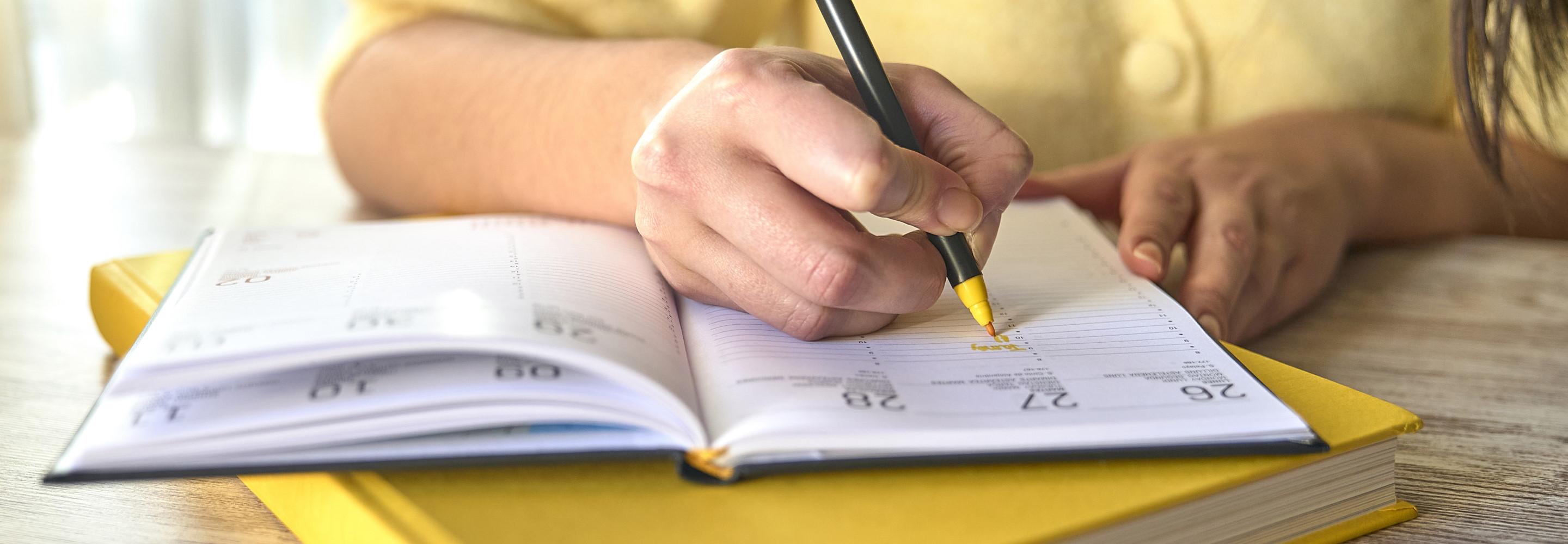 Frau notiert ihren Umzugstermin in einem Kalender