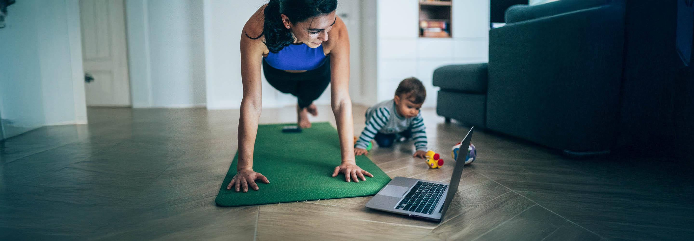 Mutter macht zuhause Sport, während ihr Baby neben ihr spielt