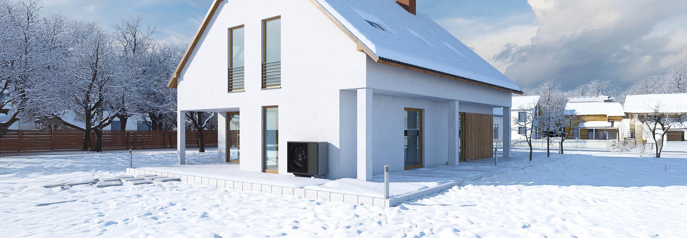 Haus mit Wärmepumpe in Schneelandschaft