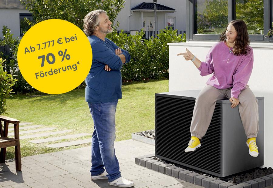 Vater und Tochter, die auf einer Wärmepumpe sitzt, unterhalten sich in ihrem Garten