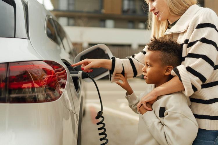Mutter und Sohn laden ein Elektroauto