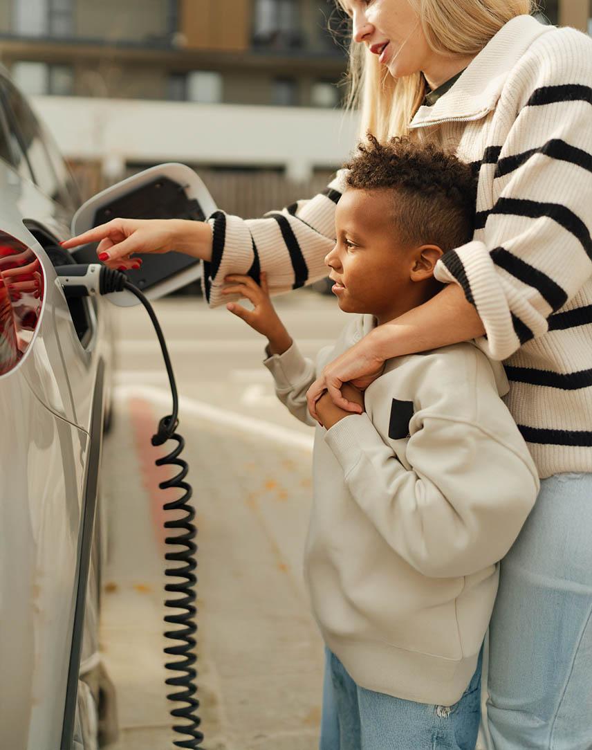 Mutter und Sohn laden ein Elektroauto